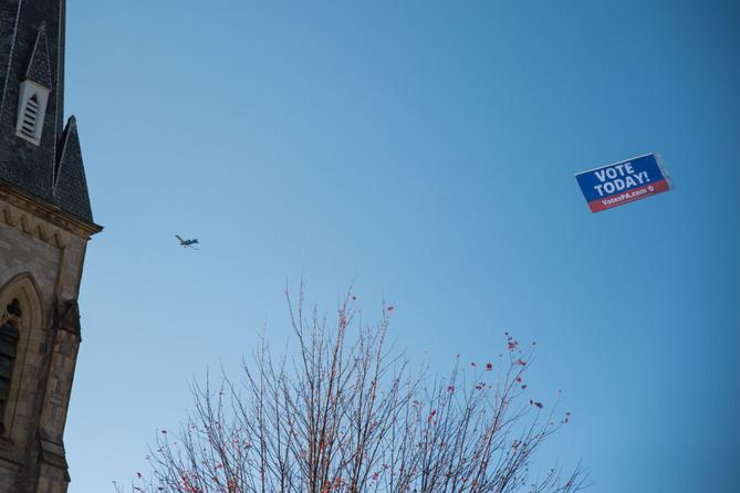 A VotesPA.com banner is flown behind a plane over downtown Erie on Election Day 2022.