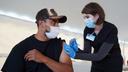 Giorgi Mushroom Company worker Juan Frutos gets a vaccine shot from Penn State Health nurse Christy Daniels during a clinic facilitated by Latino Connection's mobile unit. The Wolf administration hired the group this spring to address persistent disparities.
