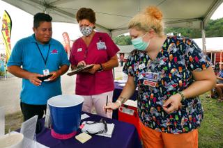 Luis Angel Guzman, a 19-year-old carnival ride worker from Mexico, talks with Wayne Memorial Community Health Center nurses at the Wayne County Fair before he got the Johnson & Johnson vaccine.