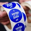 A poll worker holds voting stickers for community members Nov. 7, 2023, in Allentown, Pennsylvania.