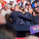 The Secret Service immediately surround former President Donald Trump after he was shot during his campaign stop at the Butler Farm Show grounds.