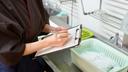 A stock image of a person with a clipboard in a kitchen. A stock image of a person with a clipboard in a kitchen.