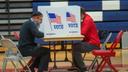 Two voters fill out ballots at Central Bucks East High School in Buckingham, Pa.