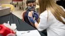 A child receives a vaccine from a nurse.