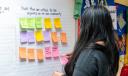 A woman in Berks County puts up a Post It note listing issues critical to her community as part of a yearlong Spotlight PA study.