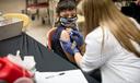 A child receives a vaccine from a nurse.