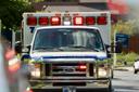 An ambulance seen head on with its lights on in the daylight. An ambulance seen head on with its lights on in the daylight.