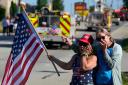 Merri Cambo of Saxonburg, Pa., and her friend, Jane Wesolosky, of Buffalo, Pa., react as the funeral procession for Corey Comperatore passes by July 19 in Sarver, Pennsylvania.