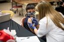 A child receives a vaccine from a nurse