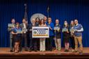 Attendees pose at a 2024 Harrisburg event celebrating a license plate featuring the state amphibian.