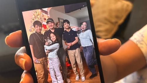 Wendys Martinez shows a photo of her and her husband, Carlos Moreno, with their family. Wendys Martinez shows a photo of her and her husband, Carlos Moreno, with their family.