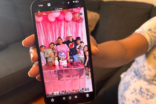 Wendys Martinez holds up her cell phone showing a photo of her husband, Carlos Moreno, and their children. Wendys Martinez holds up her cell phone showing a photo of her husband, Carlos Moreno, and their children.