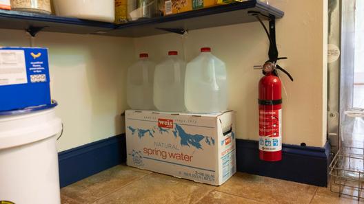 Linnet Brooks, a Rock Spring Water Company customer, keeps bottled water in her pantry due to frequent outages.