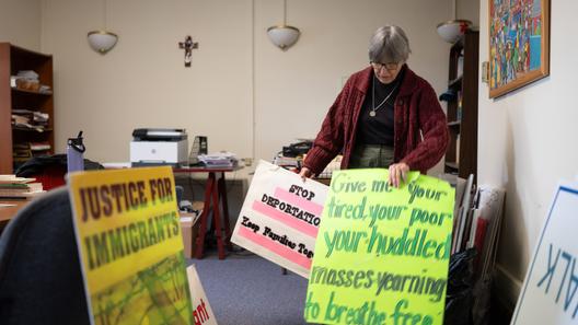 Sister Anne McCarthy with the Benedictine Sisters of Erie looks through her signs protesting President Donald Trump’s nationwide immigration crackdown. Sister Anne McCarthy with the Benedictine Sisters of Erie looks through her signs protesting President Donald Trump’s nationwide immigration crackdown.