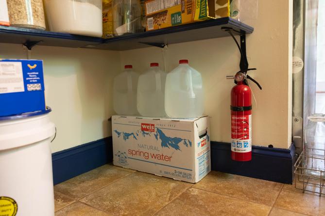 Linnet Brooks, a Rock Spring Water Company customer, keeps bottled water in her pantry due to frequent outages.