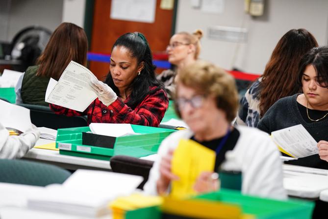 Trabajadores clasifican papeletas de voto por correo en el Centro de Gobierno del Condado de Lehigh en Allentown el 8 de noviembre de 2022.