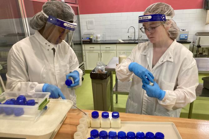 Lab workers at Mid-Atlantic Mothers' Milk Bank fill bottles with donated milk.