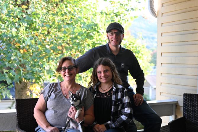 Cici, left, Essy, and Jared Brackbill pose for a photo with their dog Trinity.