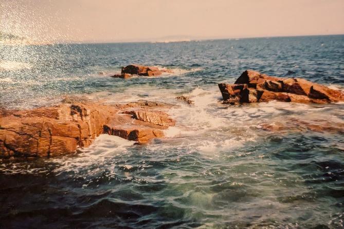 A photo of rocks in the ocean off the coast of Maine.